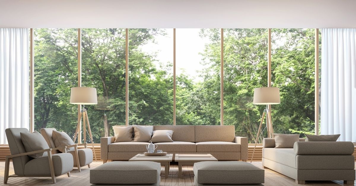 Spacious modern living room with large floor-to-ceiling windows, neutral-toned furniture, and minimal interior wall decor ideas that highlight natural light and outdoor views