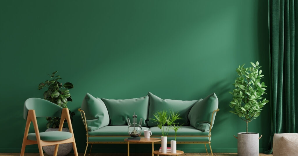 A modern green-themed room with a sofa, chair, plants, and soft lighting creates a calm, cozy vibe.