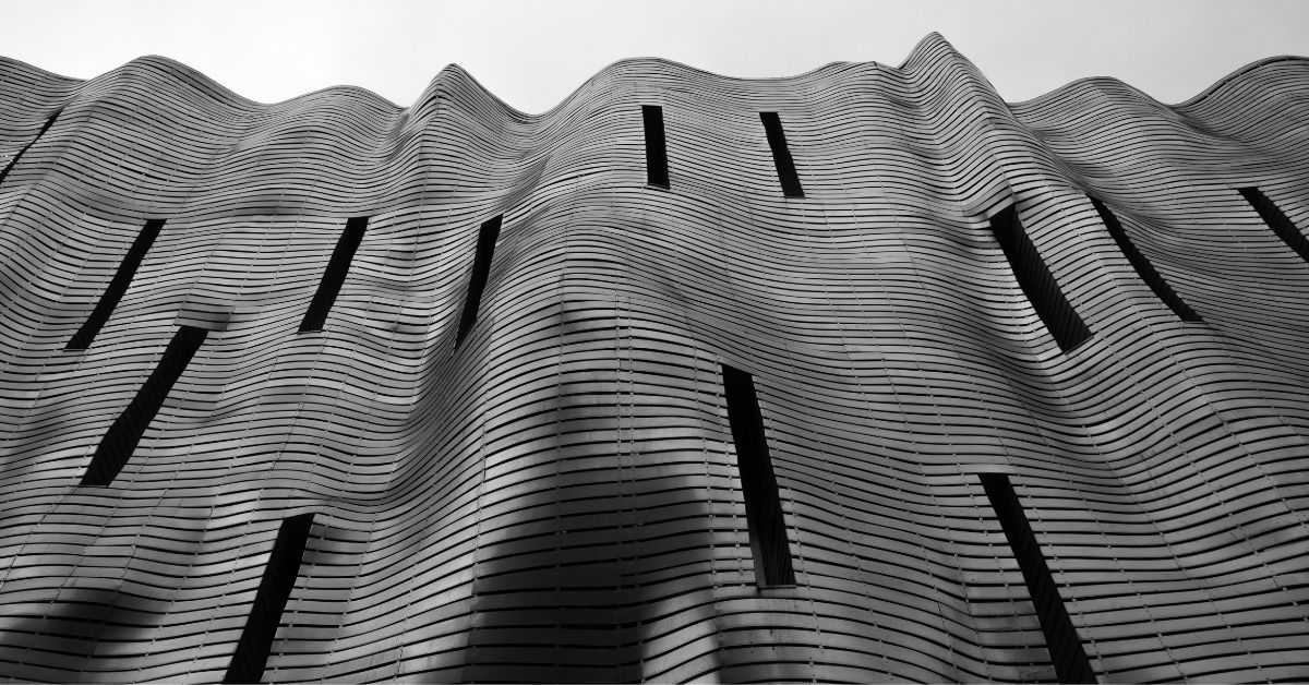 What is Contemporary Architecture – wave-like concrete facade with vertical window openings in modern building design.