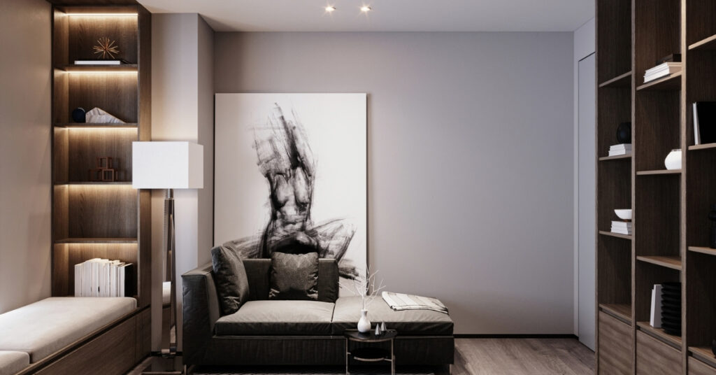 A modern, cozy room with a dark sofa, built-in shelves, and large monochrome art on the wall.