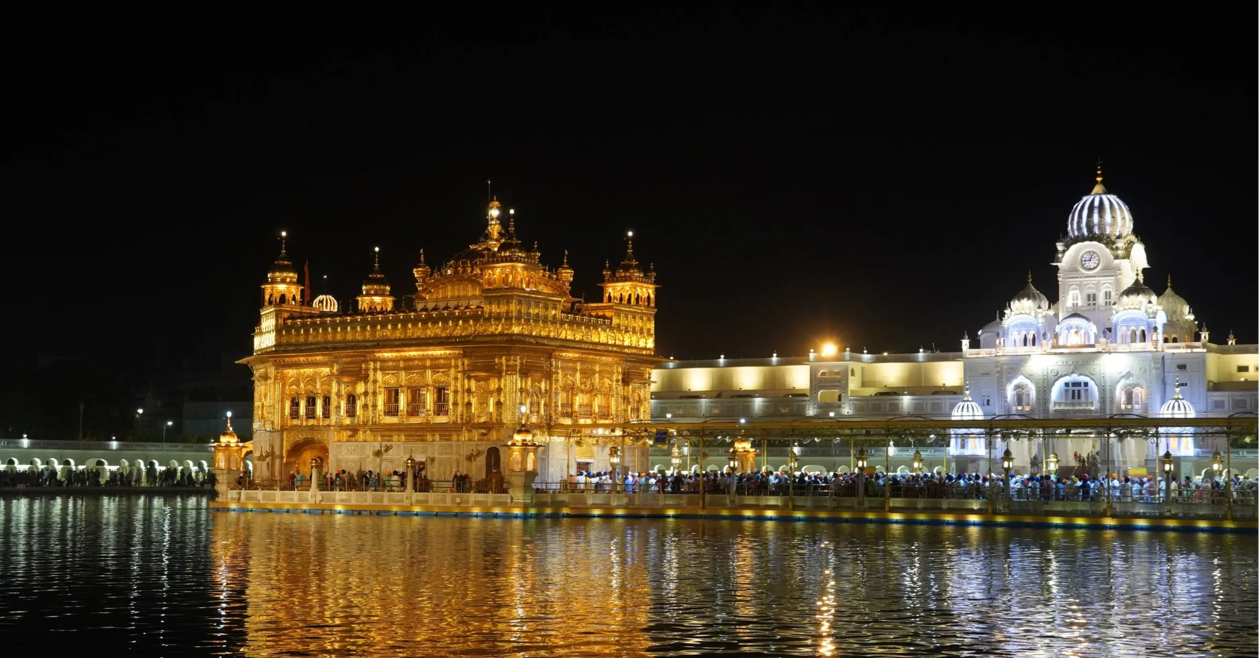 Golden Temple (Harmandir Sahib) illuminated at night, reflected in the surrounding sacred pool.