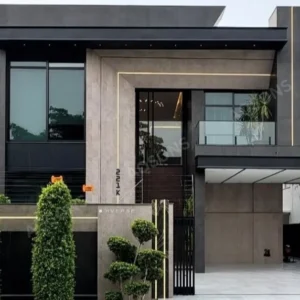 1 Kanal Residential House Plan, two-story house with a sleek, minimalist facade, rendered in contrasting colors—primarily dark grey/black and light beige/tan.